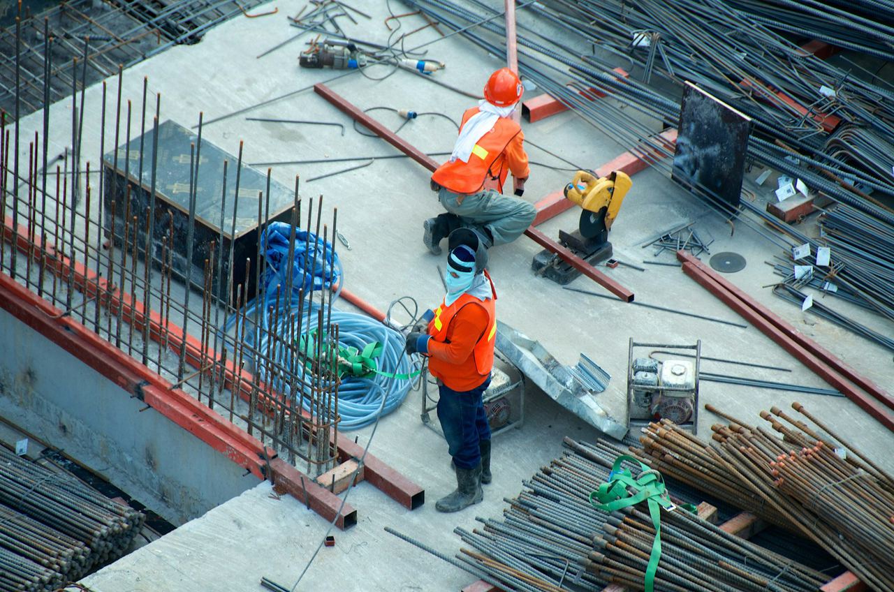 Workers laying steel reinforcement on a construction site